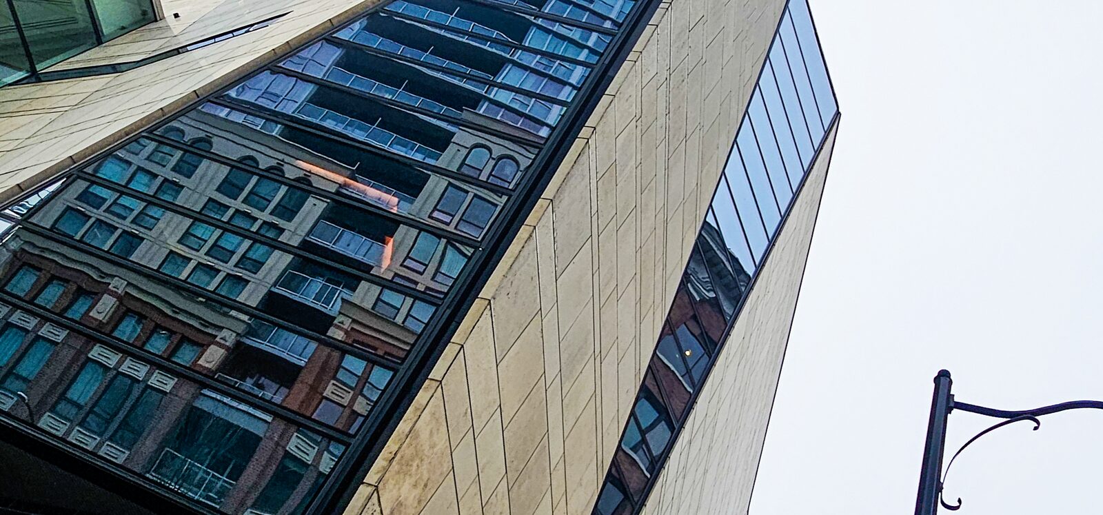 Angled limestone facade meeting the glazing